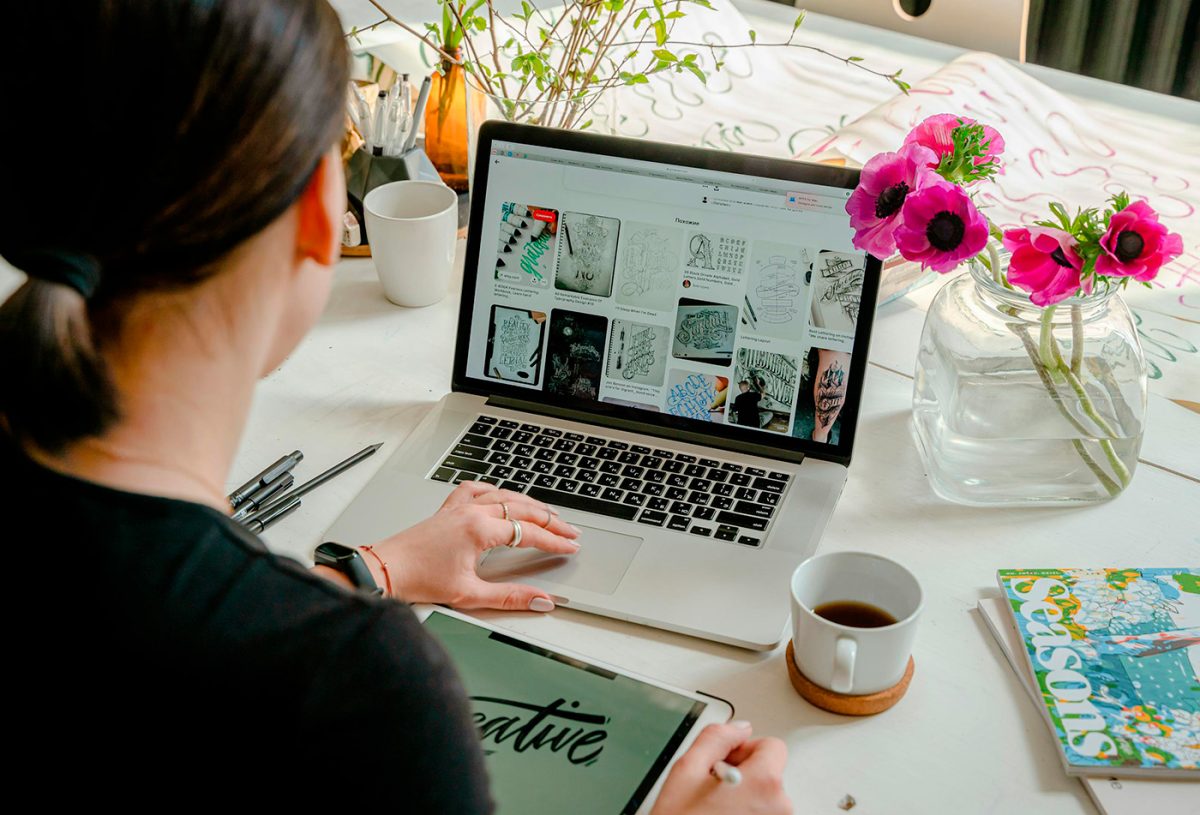 Interfaccia WordPress in fase di progettazione su schermo, accanto a una palette colori e layout grafici stampati. Parole chiave: identità visiva WordPress, branding digitale